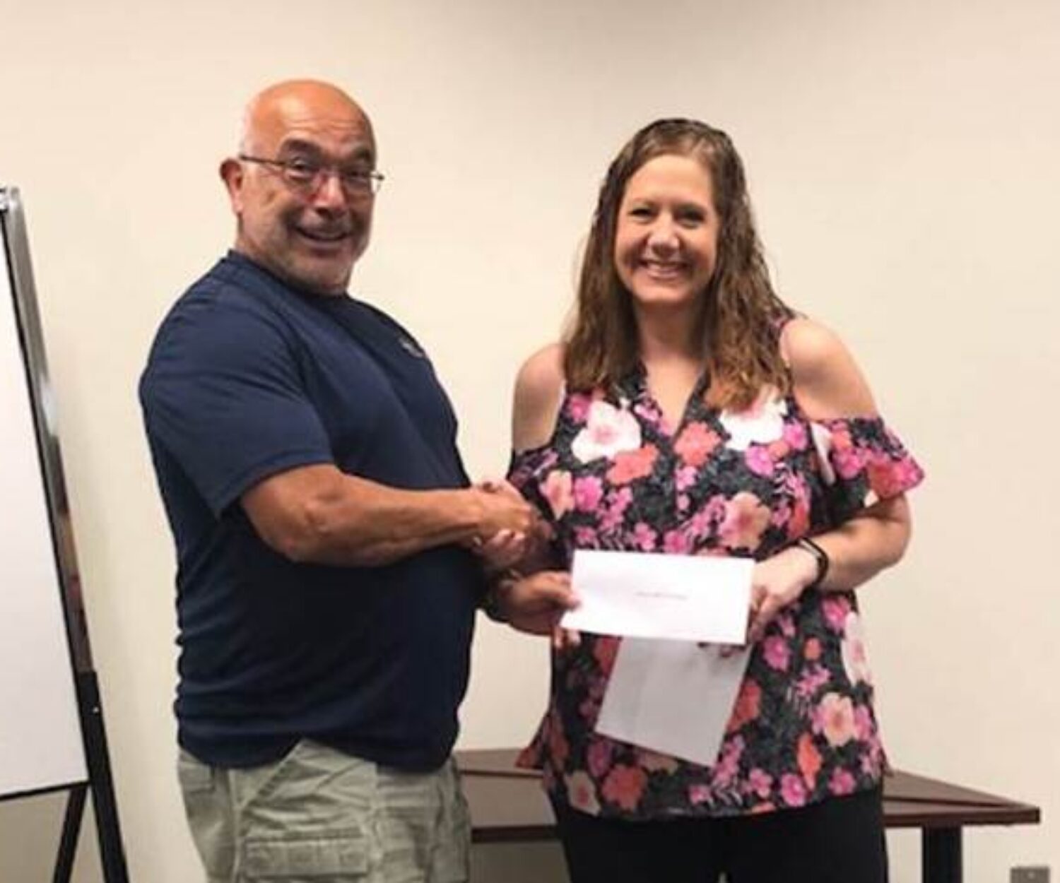 Hearts and Homes for Veterans Inc. Director David Santini, a former Army sergeant major, accepts a check on behalf of the organization from Lee County Tax Collector employee Michelle Shayer.
